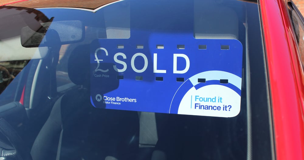 Close Brothers Motor Finance sold sign in red car
