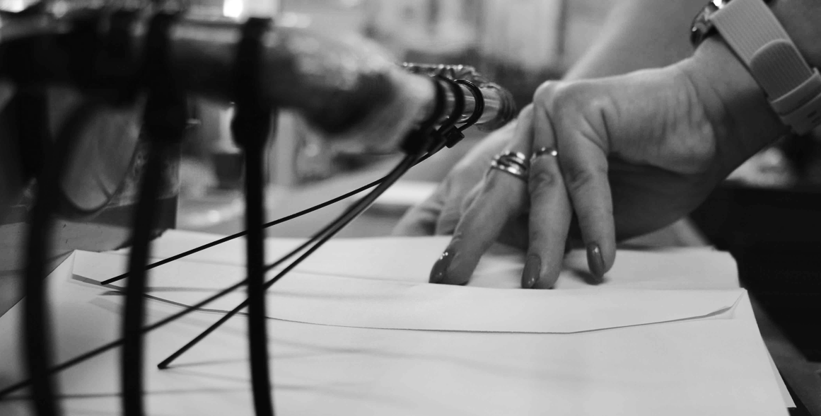 Hands taking envelopes off a mailing line