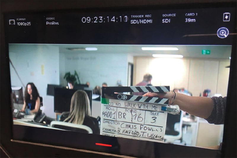 Clapperboard on screen during filming of video